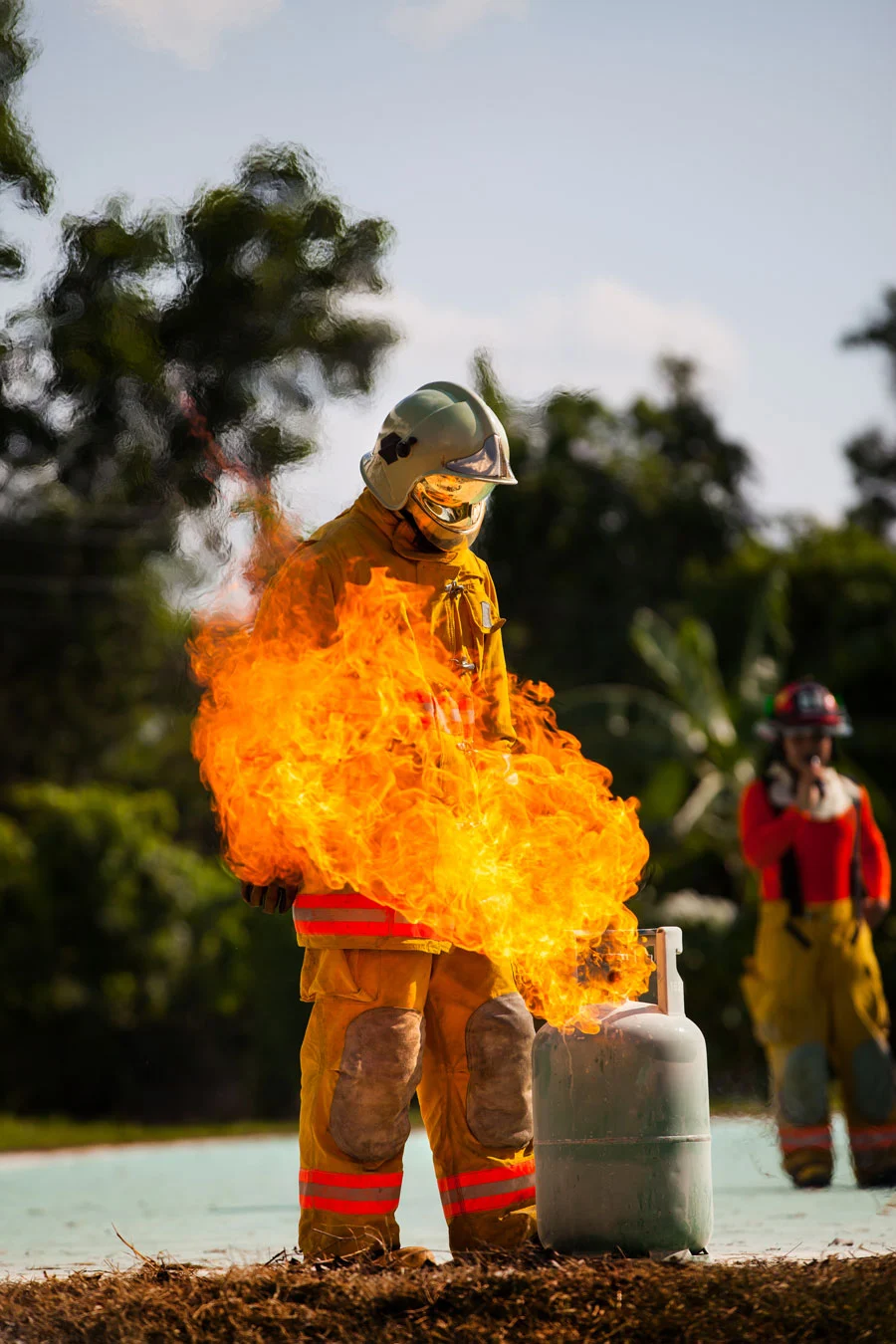 bombeiro com equipamento treinando com um botijão de gás.